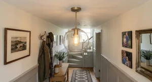 A clear glass globe pendant light for a low ceiling illuminating a narrow hallway.