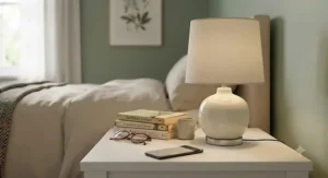 Classic ceramic base bedside lamp under £20 with a neutral fabric shade on a white nightstand