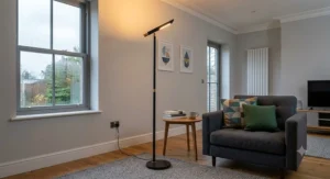A sleek matte black LED uplighter providing minimalist ambient lighting in a contemporary UK living room.
