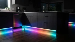Vibrant colour changing RGB plinth lights kitchen installed beneath modern handleless grey cabinets